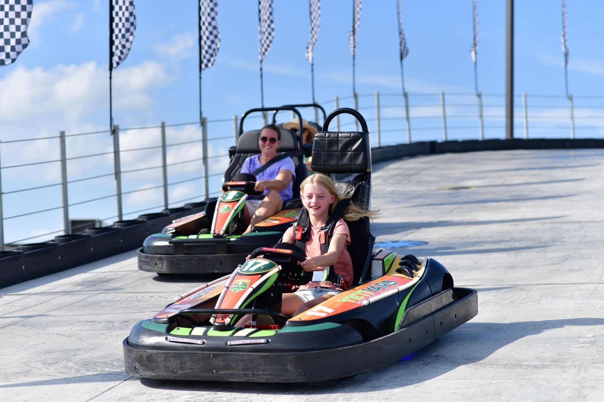 Mom and daughter racing go-karts in a close-up action shot at YetiYard